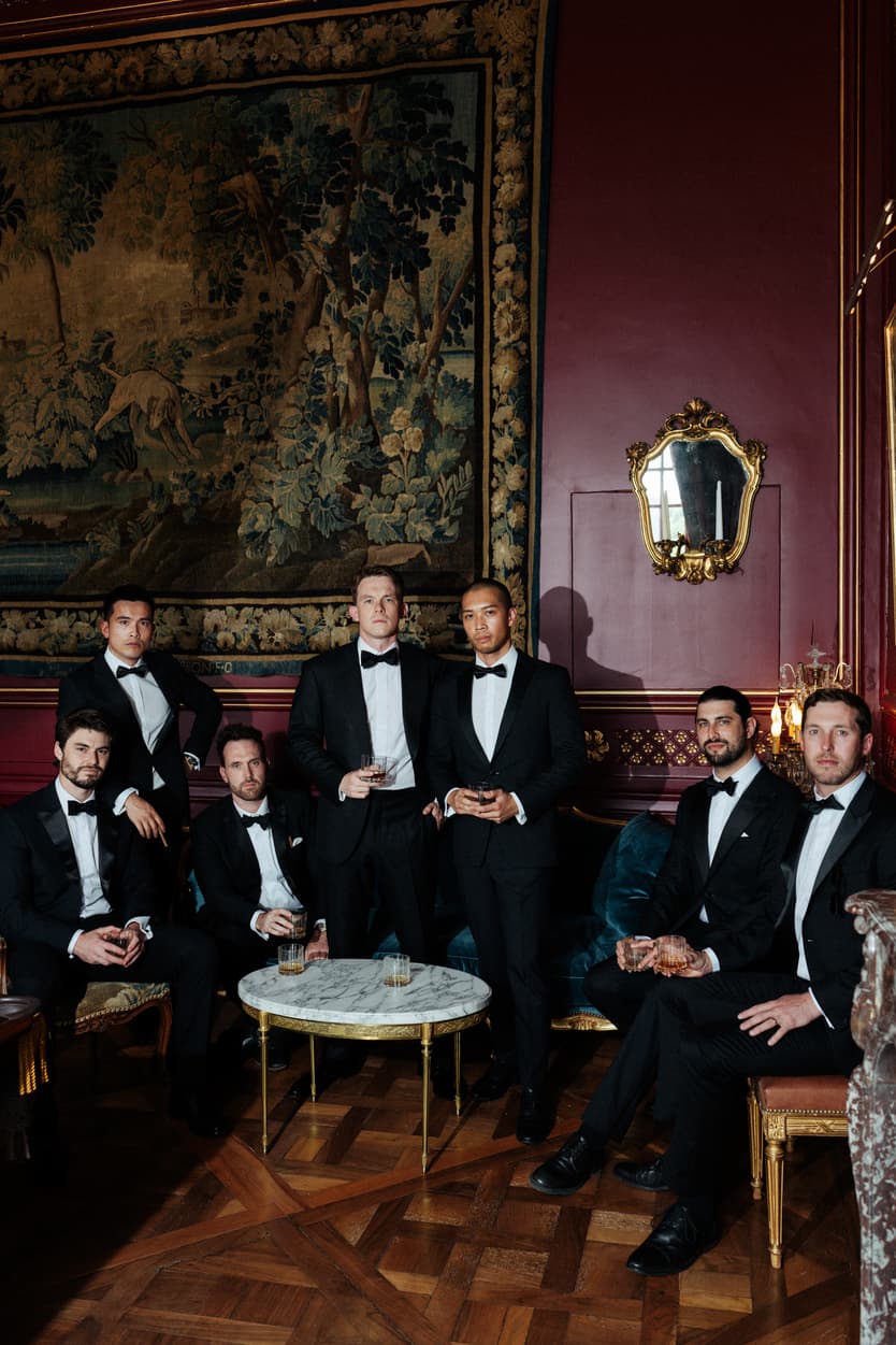 The red billiard room at Château du Grand Lucé, tapestry, gilt mirror and groomsmen in black tie