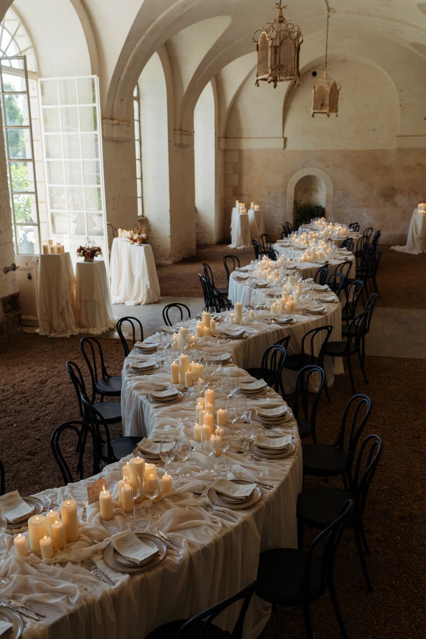 The welcome dinner laid in the orangerie of Château du Grand Lucé under its stone arches and hanging lanterns