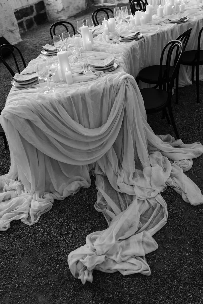 Raw silk drapery pouring off the welcome dinner table onto the gravel of the orangerie, in black and white