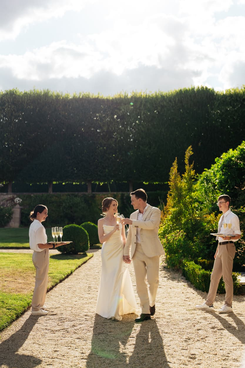 Guests walking down through the gardens of Château du Grand Lucé to the welcome dinner with champagne
