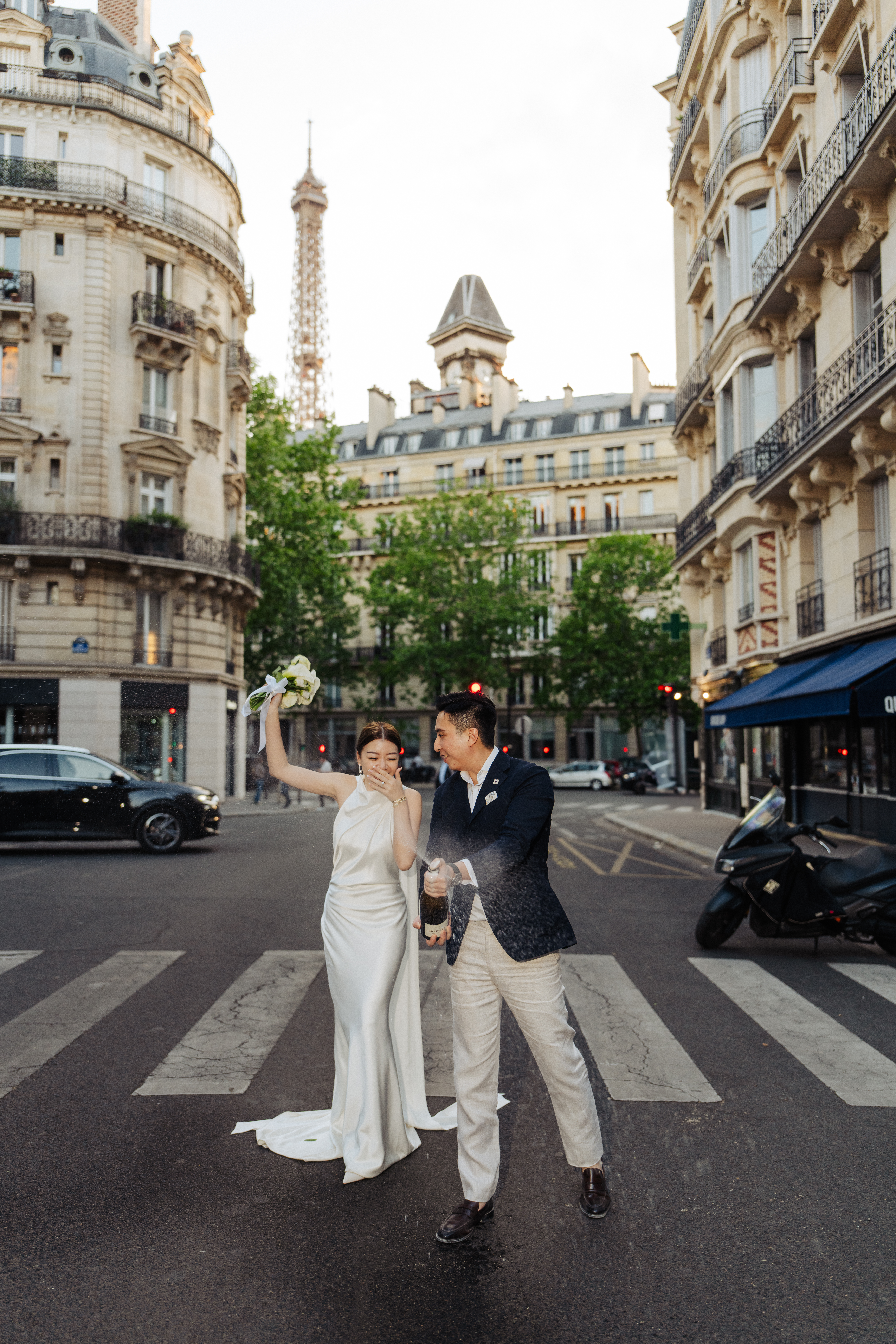 engagement photo with couple opening champagne at Eiffel tower street